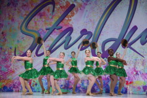 Competitive Team performing jazz dance with money props in green costume