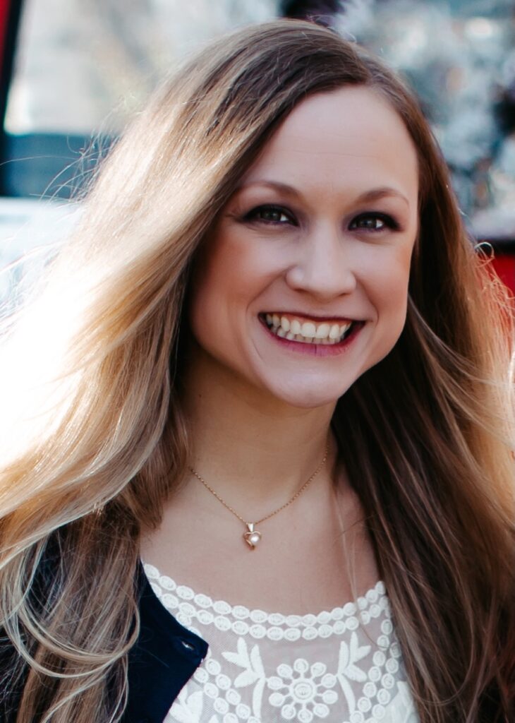 Miss Lauren headshot. Wearing a lace top and black cardigan